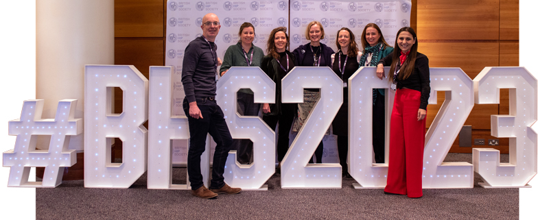 Attendees stand with a #BHS2023 sign in the foyer